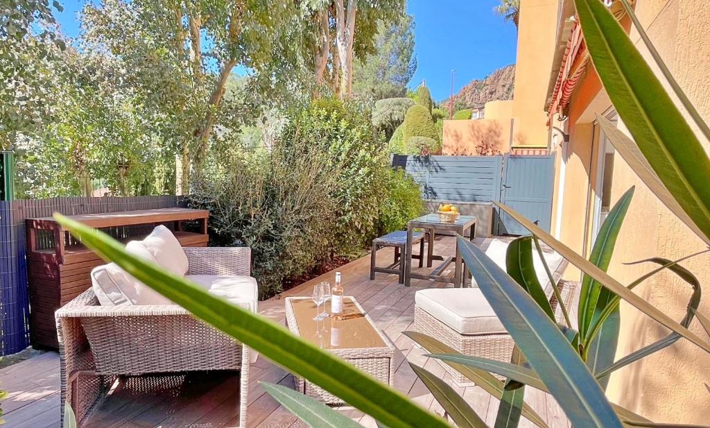 a patio with a table and chairs and plants at Renovated 2-room apartment near sea & shops in Théoule-sur-Mer