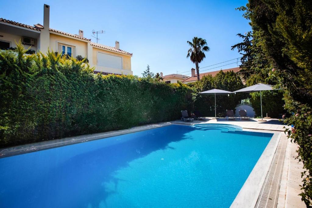 ein Swimmingpool vor einem Haus in der Unterkunft South Blue Tranquil Villa in Athen