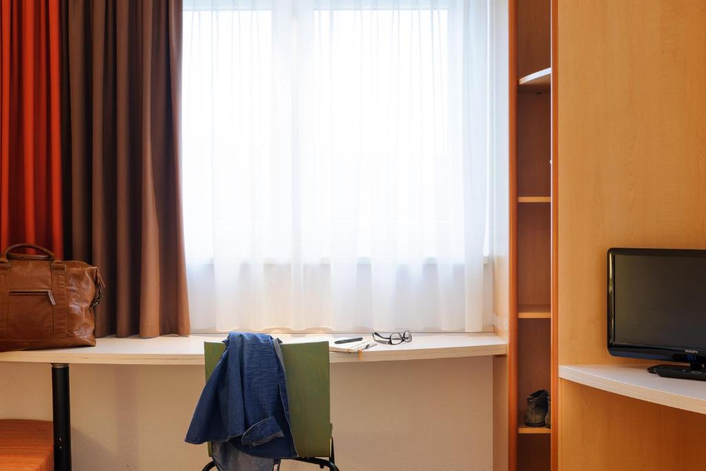 TV a/nebo společenská místnost v ubytování ibis Berlin Dreilinden