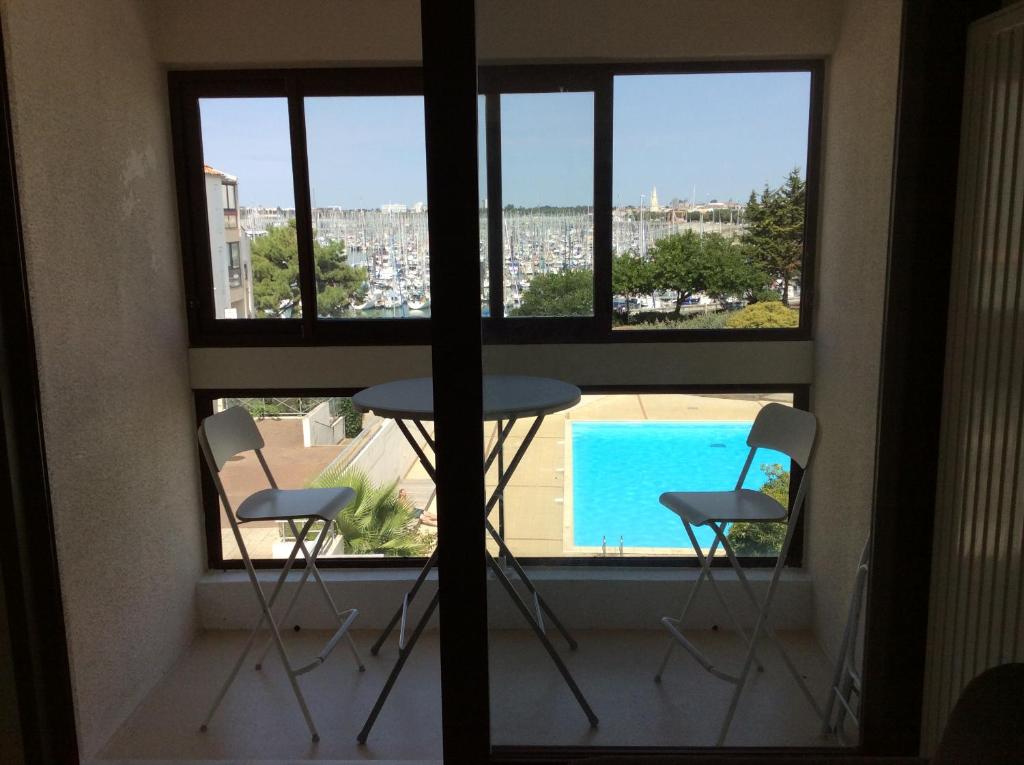 - un balcon avec deux chaises, une table et une piscine dans l'établissement Vue sur Marina, à La Rochelle