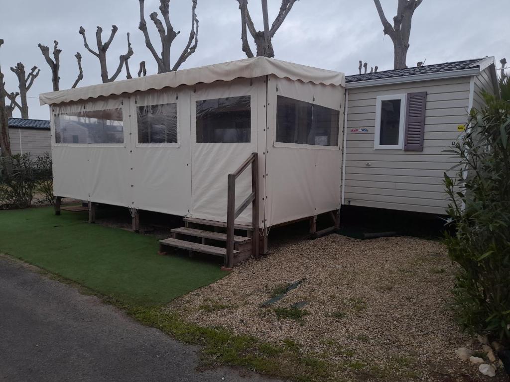 una gran casa blanca con techo en MOBIL HOME la STEPHANOISE, en Valras-Plage