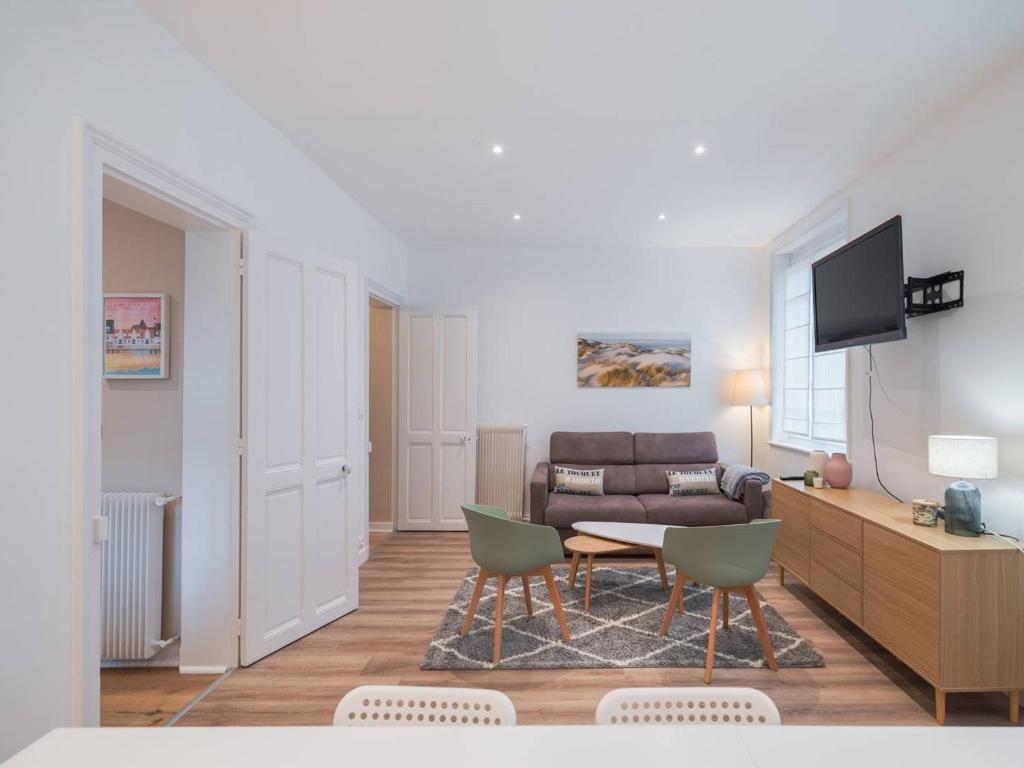 un salon avec un canapé, une table et des chaises dans l'établissement Appartement familial au centre-ville avec balcon et WIFI - FR-1-821-7, à Le Touquet-Paris-Plage