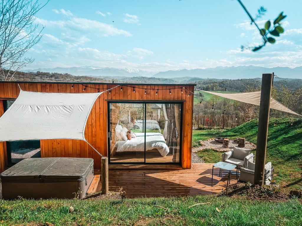 LasseubeChalet insolite - SPA - Vue Pyrénées - Brasero的小型帐篷,配有一张床和一张椅子,位于甲板上