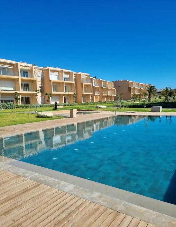 塔哈佐特Taghazout Paradise - Duplex Confort - Vue mer piscine - Agadir的建筑物前的一个大型游泳池