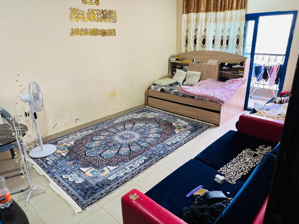 a room with a bed and a rug on the floor at Single private room with shared washroom and kitchen in Sharjah