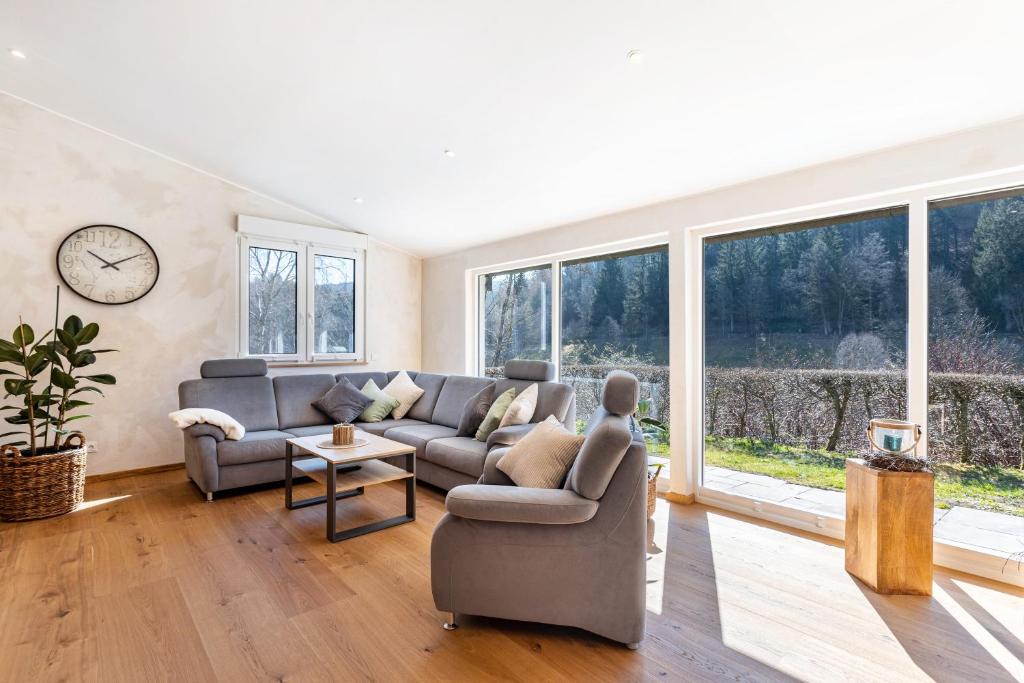 a living room with a couch and a clock at Ferienhaus Wiese in Schmallenberg