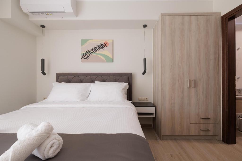 une chambre avec un lit et une armoire en bois dans l'établissement Plaka Studios 2, à Benitses