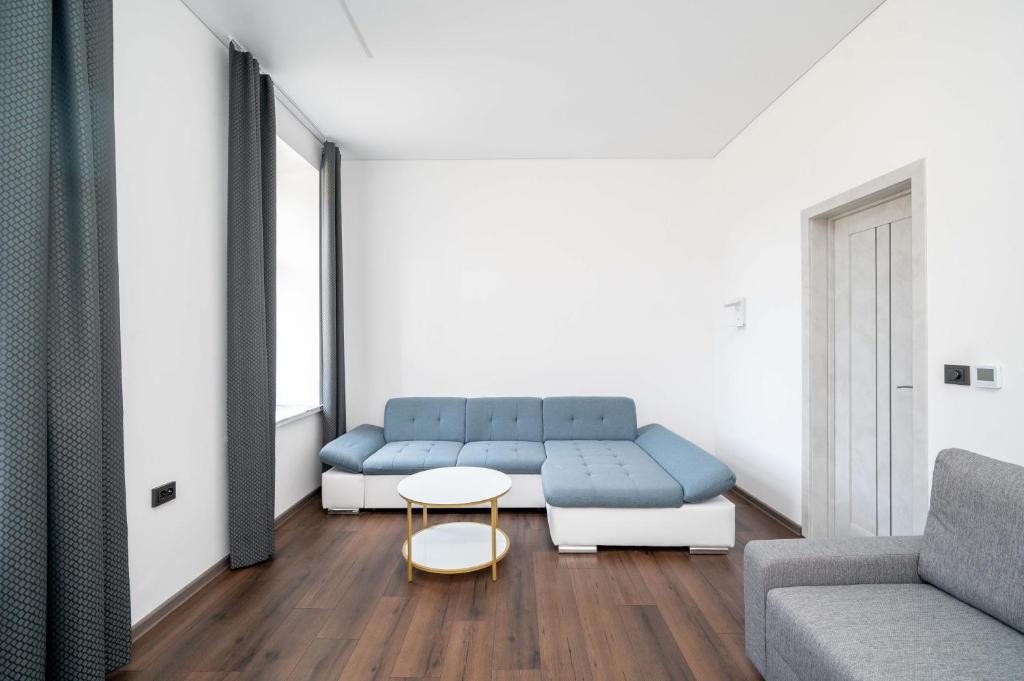 un salon avec un canapé bleu et une table dans l'établissement Stylish property, Self check in 24h, Netflix, parking, à Vilnius