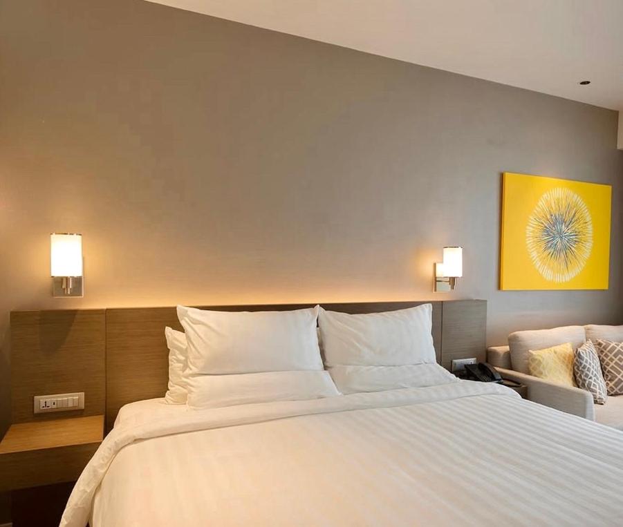 Un dormitorio con una cama grande con almohadas blancas. en The Hotel at Tower Acqua 1, en Manila