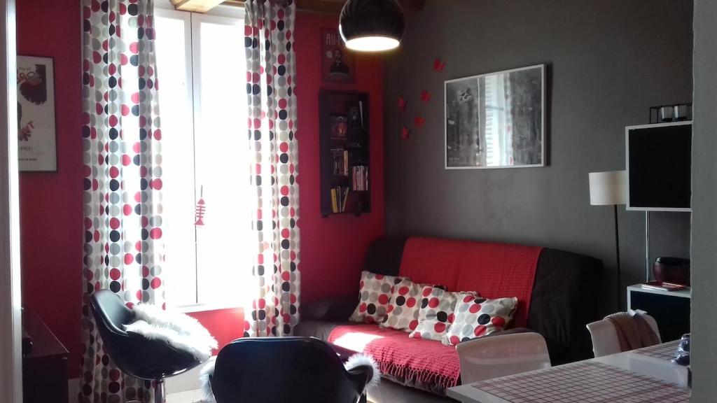 - un salon avec un canapé rouge et une fenêtre dans l'établissement Charmant 2 pièces, hyper-centre, Avenue de la Mer, à Cabourg