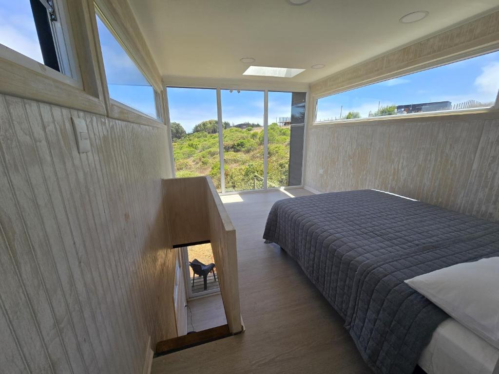 ein Schlafzimmer mit einem Bett und einem Kamin in der Unterkunft Koru Ecolodge in Cáhuil