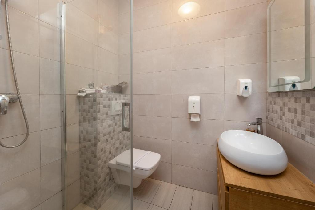 ein Badezimmer mit Dusche, Toilette und Waschbecken in der Unterkunft Villa Okruk-10 meters away from the beach in Trogir