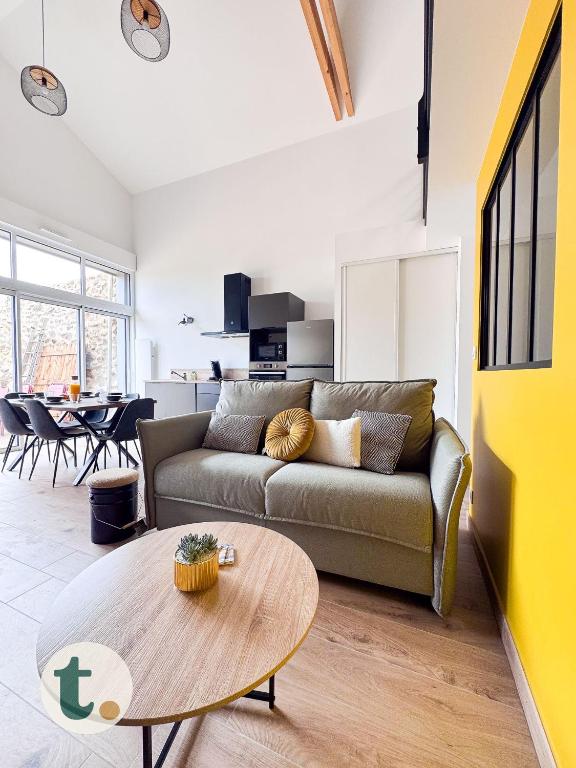 un salon avec un canapé et une table dans l'établissement Tranquiloue - Le Nid de Mila - 10 min du PuyduFou, aux Herbiers