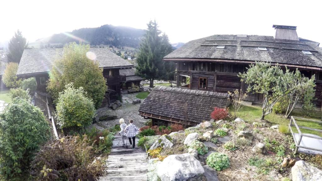 a woman walking down a path in front of a house at Les Fermes de Marie in Megève