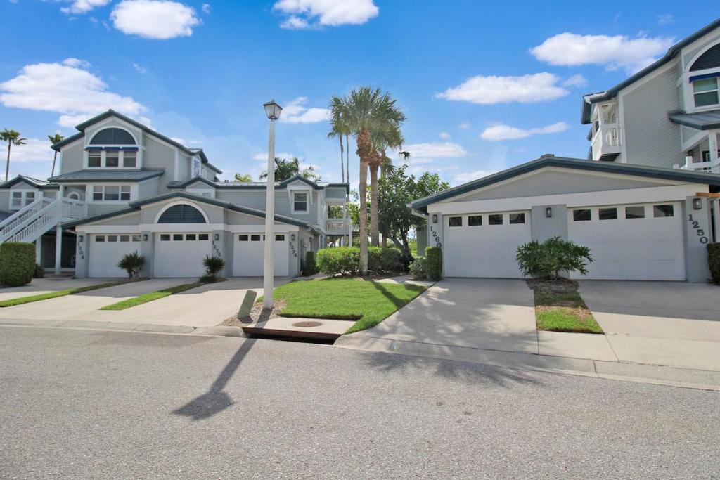 a house with white garage doors on a street at Beach Access - Tennis - Two Pools - Fishing Dock in Siesta Key