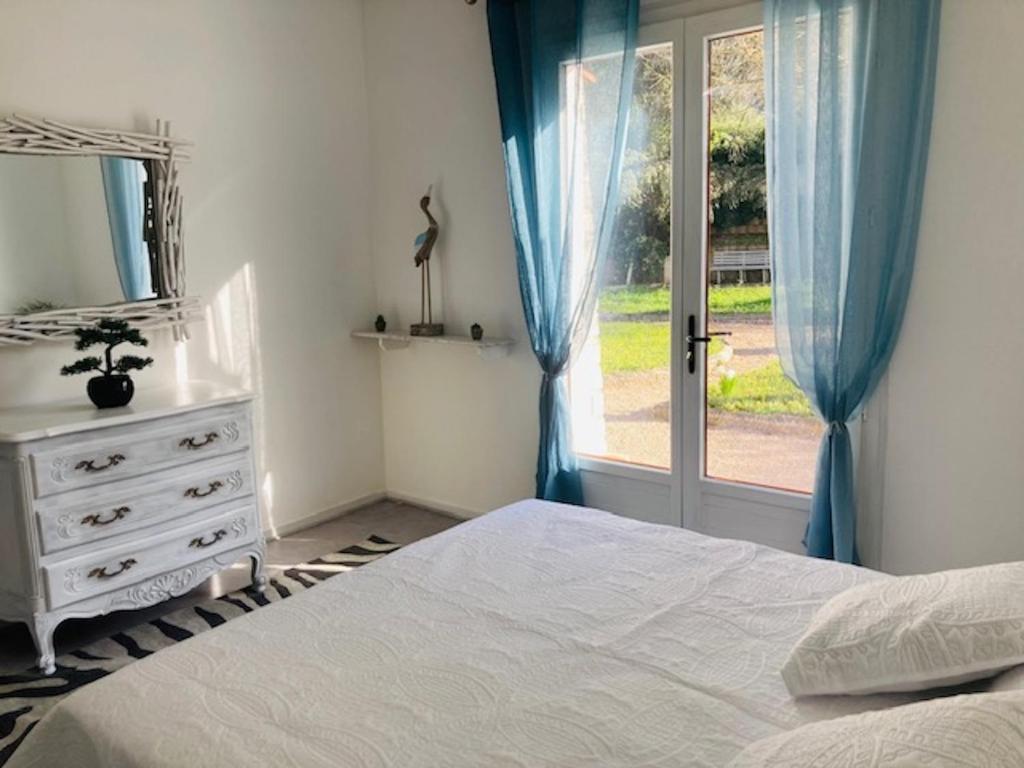a bedroom with a bed and a dresser and a window at Maison provençale de Plain pied avecGrand jardin et Piscine in Aubagne