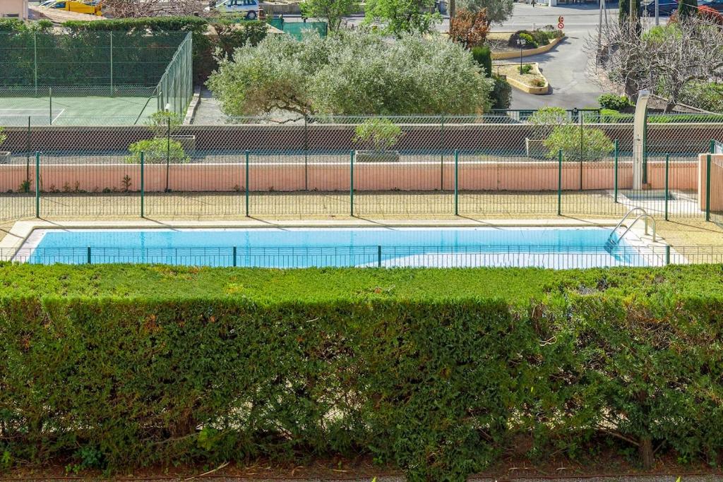 une piscine dans un parc avec une clôture dans l'établissement Saint Charles YourHostHelper, à Saint-Raphaël