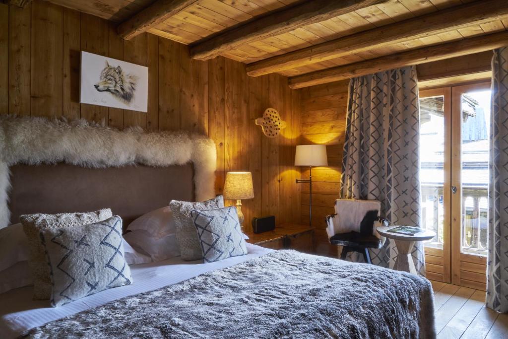 a bedroom with a bed in a room with wooden walls at Les Fermes de Marie in Megève