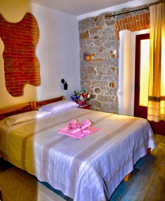 a bedroom with a bed with two pink towels on it at Il Giglio Affittacamere in Tortolì
