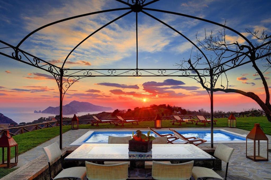 une piscine avec vue sur le coucher du soleil en arrière-plan dans l'établissement Casa del Capitano with Heated Pool, Views and Concierge by Feeling Italy, à Massa Lubrense