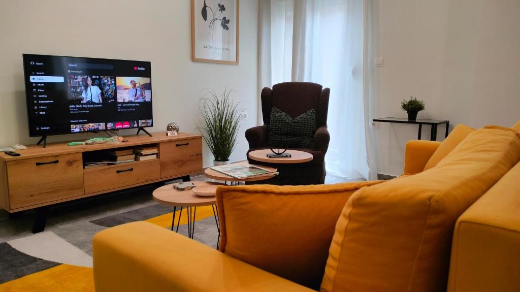 a living room with a couch and a flat screen tv at N&K Yellow Pearl Flat in Volos