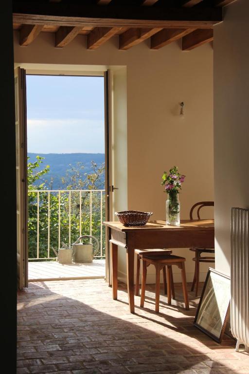 une salle à manger avec une table et une grande fenêtre dans l'établissement La Petite Montjoie - Maison vigneronne, à Tharoiseau