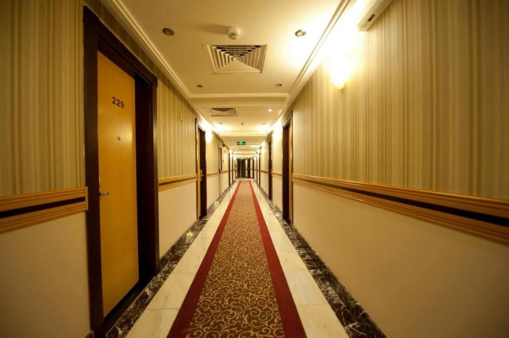 a long corridor with a red carpet in a building at فندق الفجر البديع 5 in Jarwal