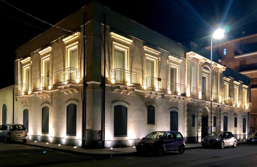 a building with cars parked in front of it at night at EUREKA APArtment in Catania