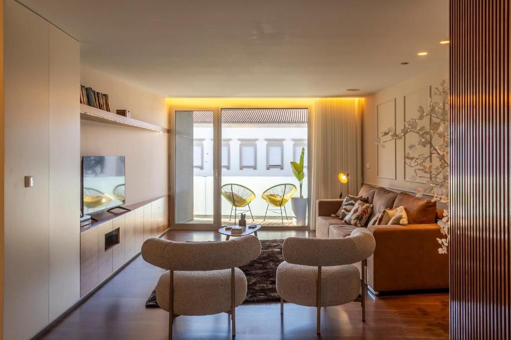 a living room with a couch and a table and chairs at Terraço da Vila in Lousada