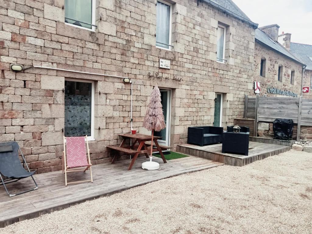un patio avec des chaises et une table en face d'un bâtiment en briques dans l'établissement Triagoz, à Trébeurden