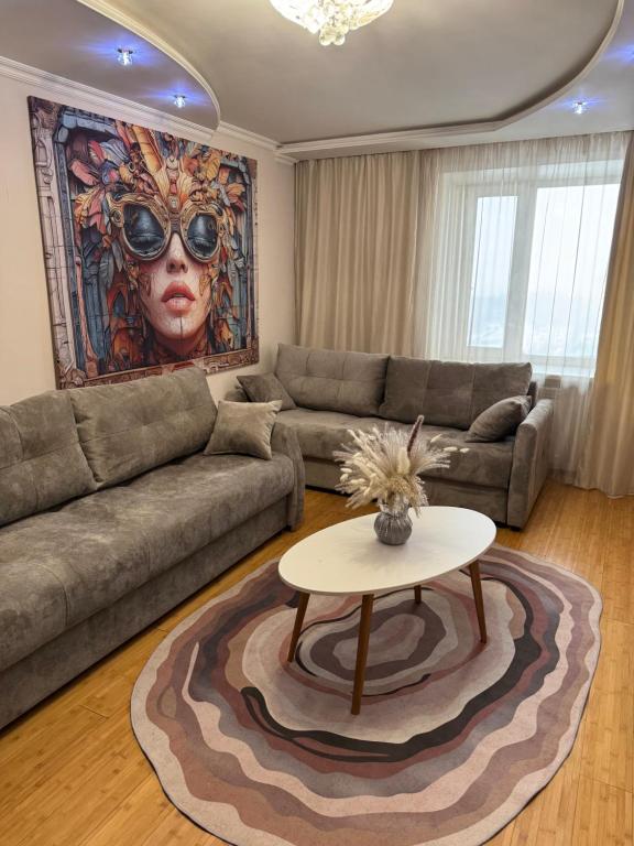 een woonkamer met een bank en een tafel bij Ермекова 52 in Karagandy