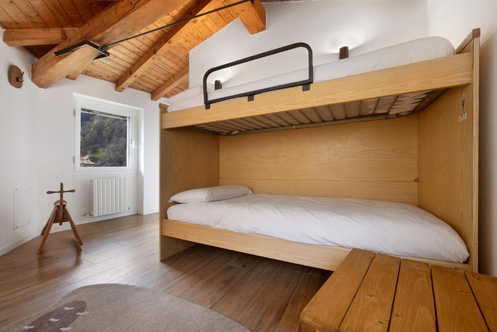 a bedroom with a bunk bed and a wooden floor at Family House Il Butto in Erve