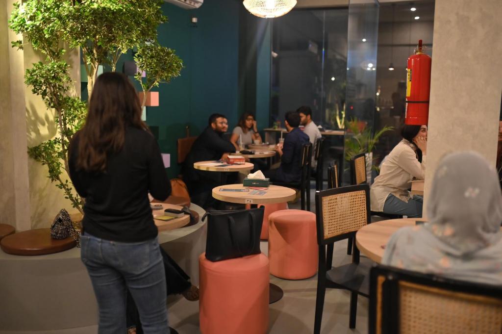 a group of people sitting at tables in a restaurant at LOKAL Flagship x Karachi - DHA in Karachi