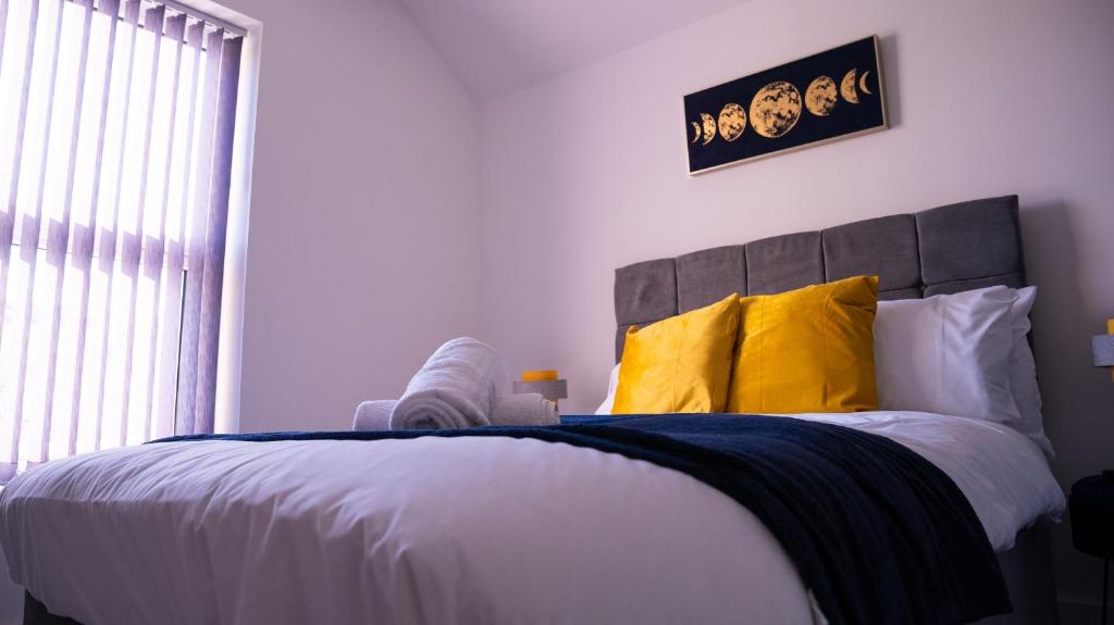 a bedroom with a large bed with yellow pillows at Prestige Stays Cardiff Modern 1-Bed Apartment near City Centre Wi-Fi & Lockbox Check-In in Cardiff