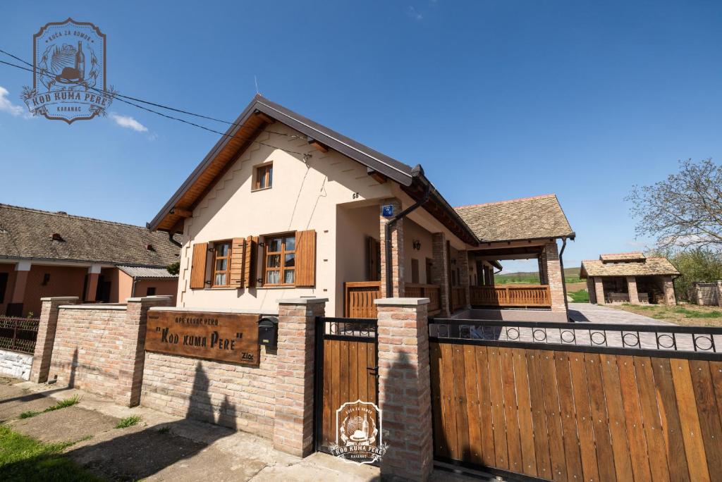 una casa con un cancello in legno e una recinzione di Kod Kuma Pere, Traditional Baranja Getaway a Karanac