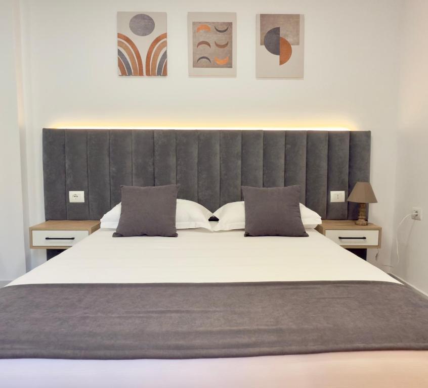 a bedroom with a large bed with a large headboard at Voda apartments in Ksamil