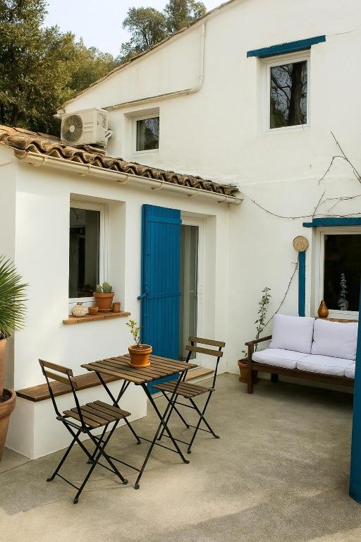 un patio avec une table et des chaises devant une maison dans l'établissement Magnifique maisonnette proche du centre-ville d Aix, à Aix-en-Provence