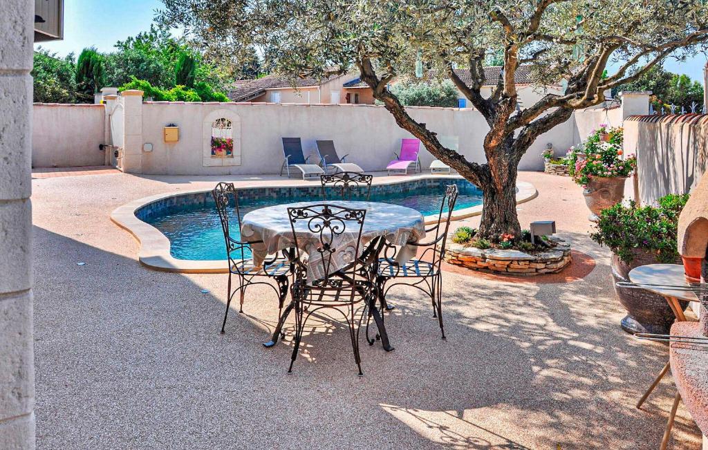 a table and chairs next to a swimming pool at Cozy Home In Chateaurenard in Châteaurenard