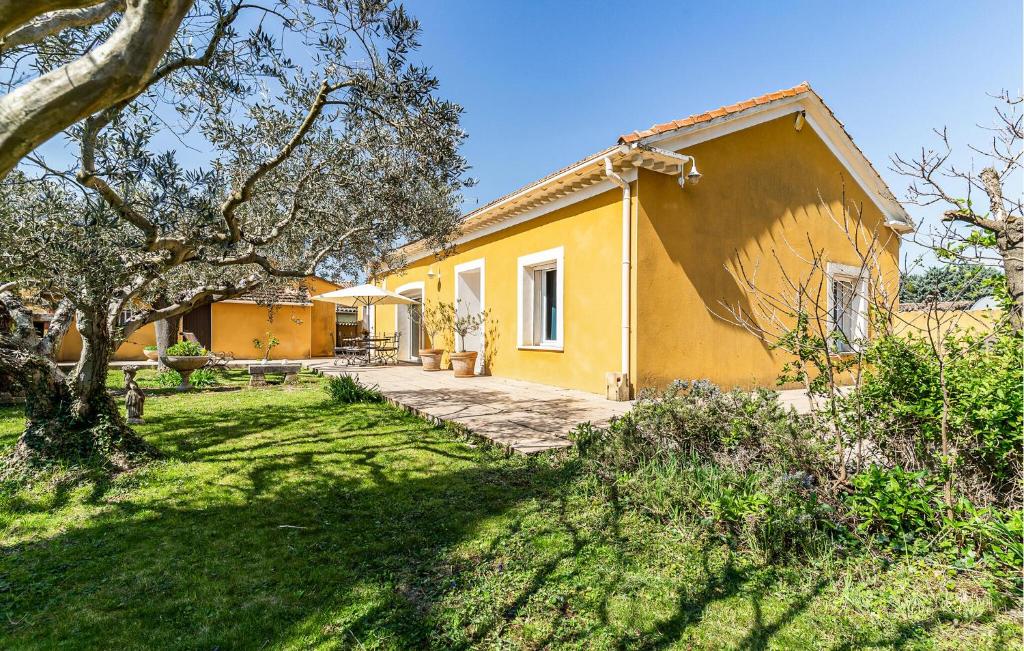 ein gelbes Haus mit einem Hof davor in der Unterkunft 2 Bedroom Amazing Home In Noves in Noves