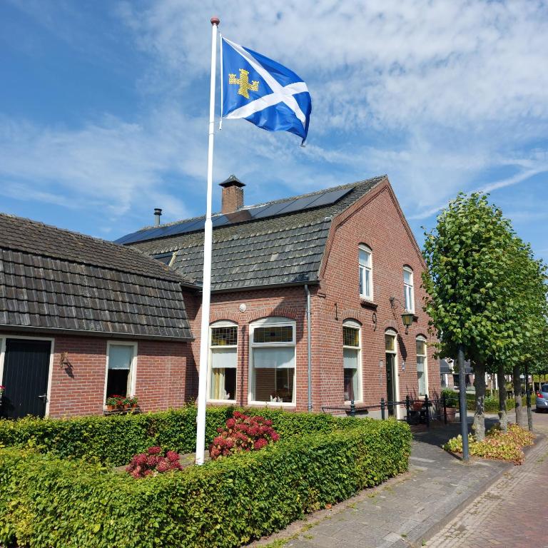 a flag flying in front of a brick house at Bed&Breakfast ons Oda in Sint-Oedenrode