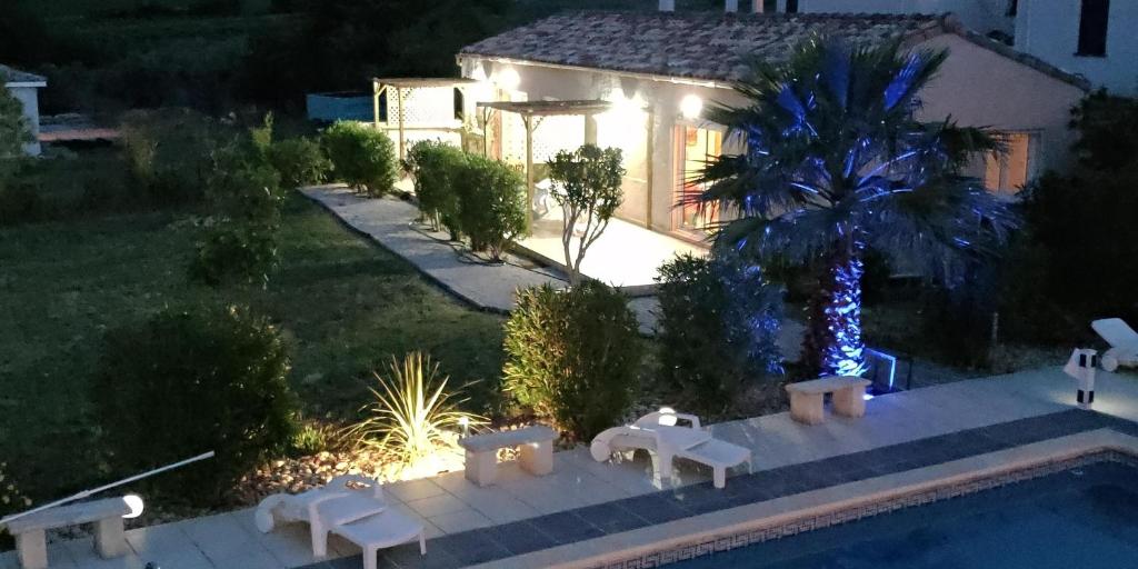 une villa avec une piscine la nuit dans l'établissement Gîte Soleil, à Adissan
