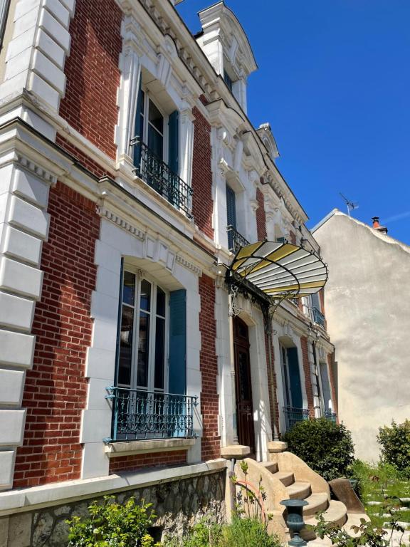 a large brick building with stairs in front of it at Assarag in Brienon-sur-Armançon