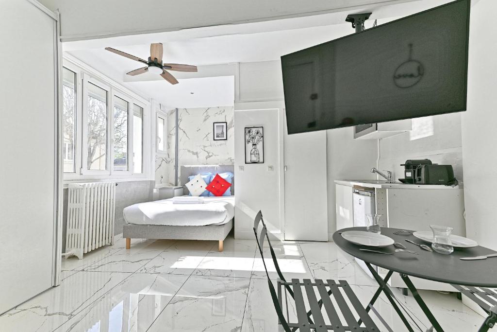 un salon avec une table et une télévision dans l'établissement Studio Les Lilas, aux Lilas