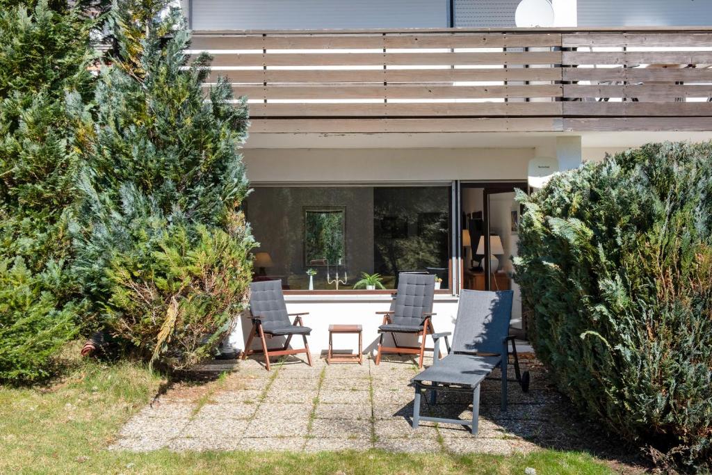 a group of chairs sitting on a patio in front of a house at Ferienwohnung Victoria in Schonwald im Schwarzwald