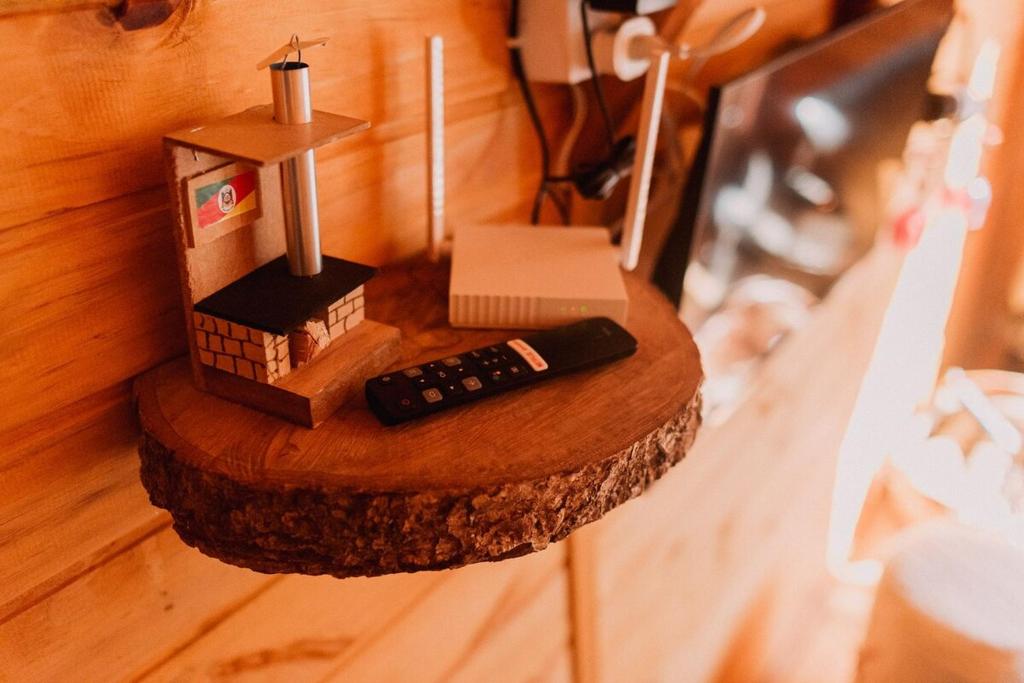 a small model of a house and a remote control at Recanto dos Xaxins in São Francisco de Paula