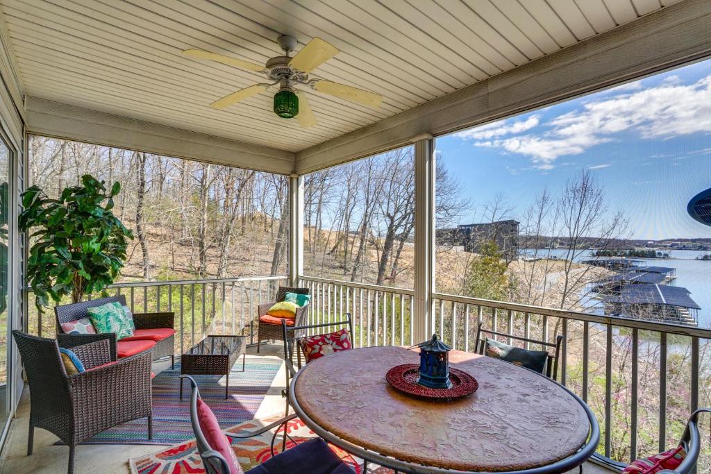 a screened in porch with a table and chairs at Waterfront Condo with Pool on Lake of the Ozarks in Lake Ozark