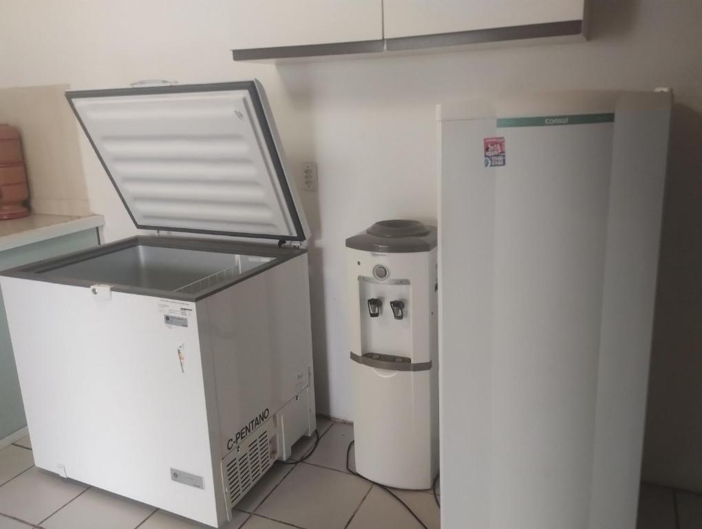 a kitchen with a refrigerator and a trash can at Tabuleiro Beach in Aquiraz