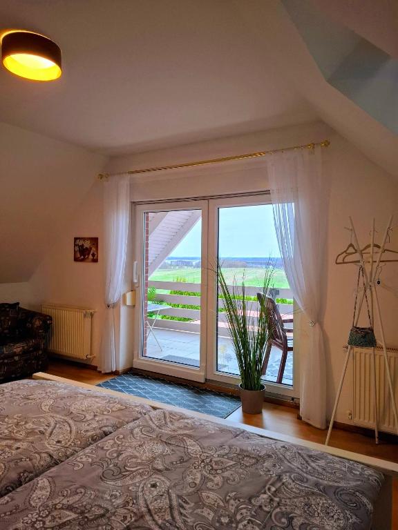 Neu SchloenにあるFerienwohnung Seeblickのベッドルーム1室(ベッド1台、大きな窓付)