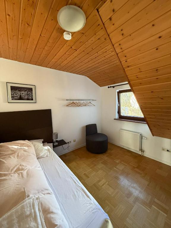 ein Schlafzimmer mit einem Bett und einem Stuhl darin in der Unterkunft Zum Griechen Restaurant und Pension in Forchtenberg