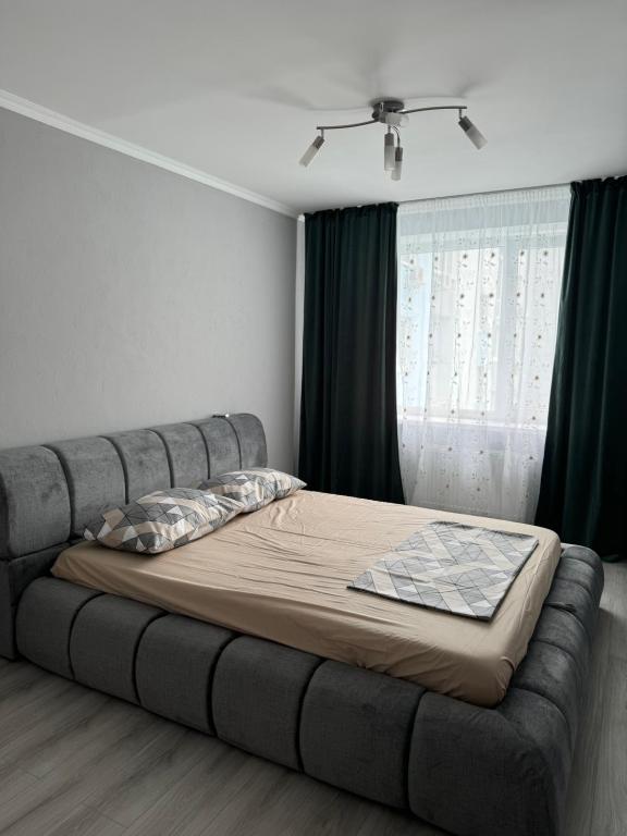a large bed in a room with a window at Стильна і сучасна квартира з двома спальнями біля Дніпра! in Cherkasy